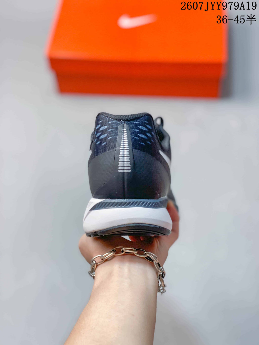 Rear view showing the dark heel counter, reflective-looking vertical heel detail and white midsole.