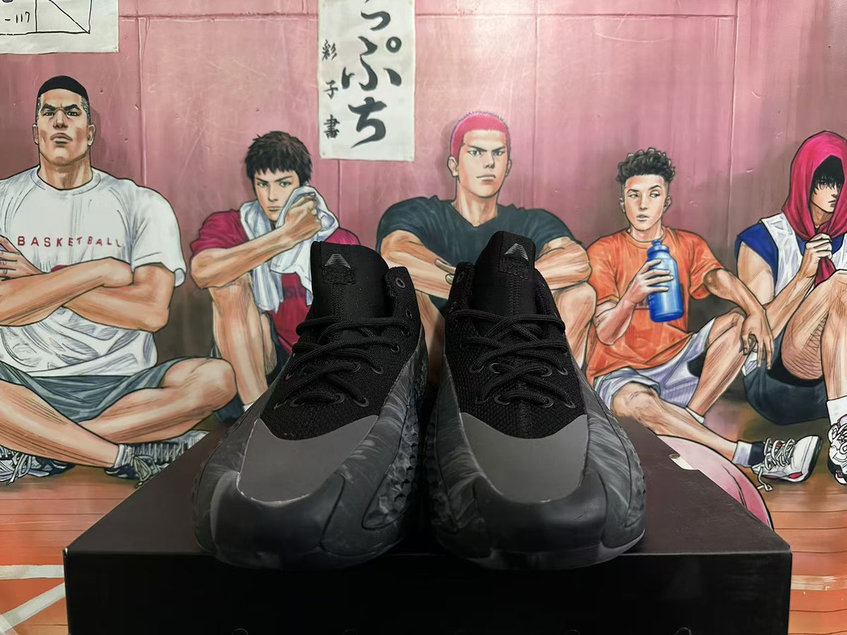 Front view of black and dark gray high-top basketball shoes with lace-up closures.