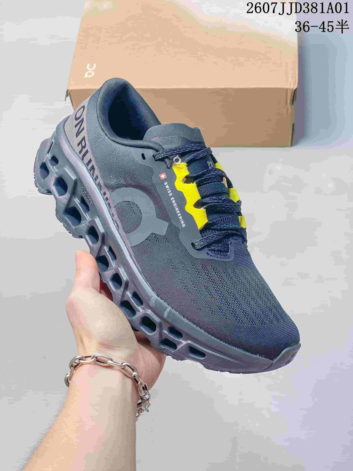 Angled side view showing the shoe’s dark grey upper, yellow lace accents, and sculpted sole.