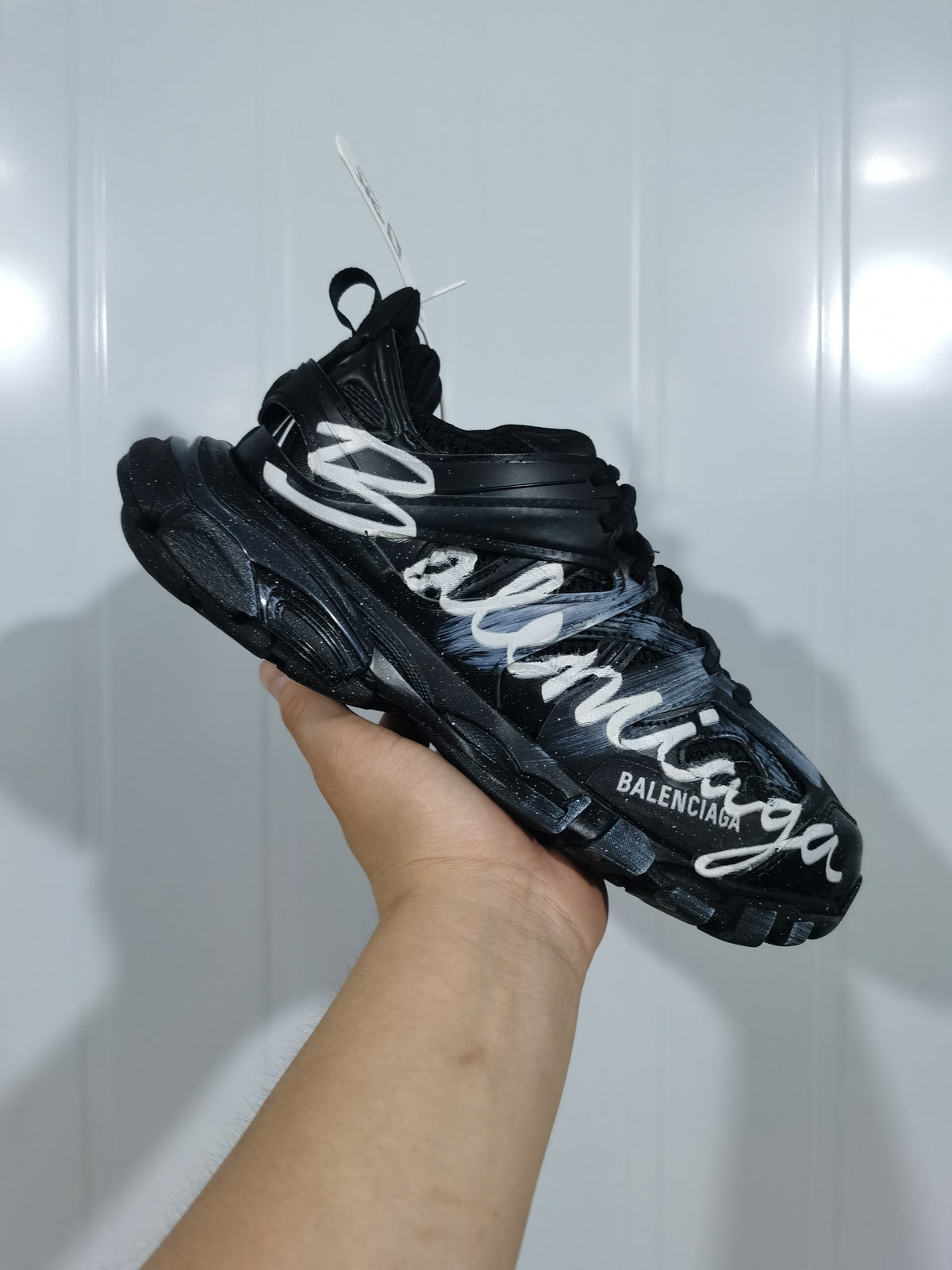 Angled view of the black Balenciaga Track sneaker showing layered panels, white lettering, and chunky outsole.