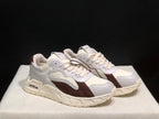 Three-quarter view of the white and brown sneaker pair with contrasting overlays and off-white soles.