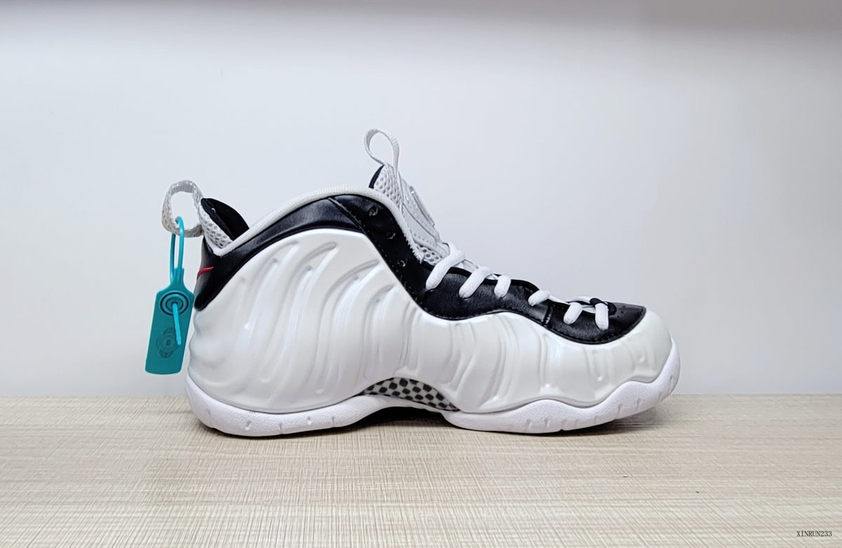 Side profile of a cream-white Nike Air Foamposite Pro shoe with black trim