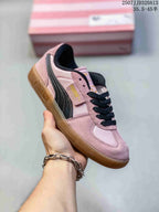 Angled side view of the pink PUMA Palermo sneaker with black stripe and gum-colored sole.