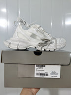 Side profile of the snow white sneaker resting on its box; the label shows style information, color "SNOW WHITE," and size C 37.