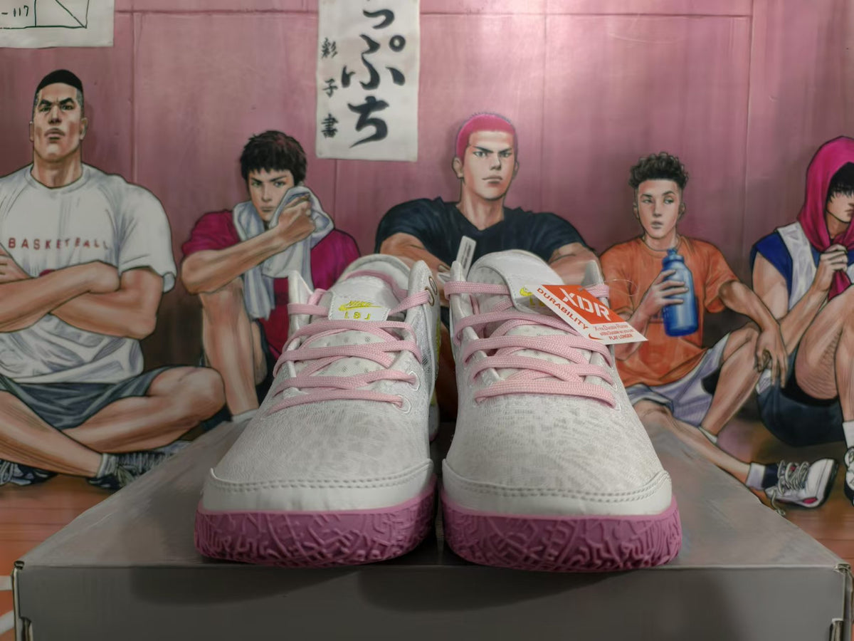 Front view of white Nike basketball sneakers with pink laces and textured pink outsoles