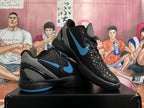 Pair of black basketball shoes with blue Swoosh accents and gray heel panels