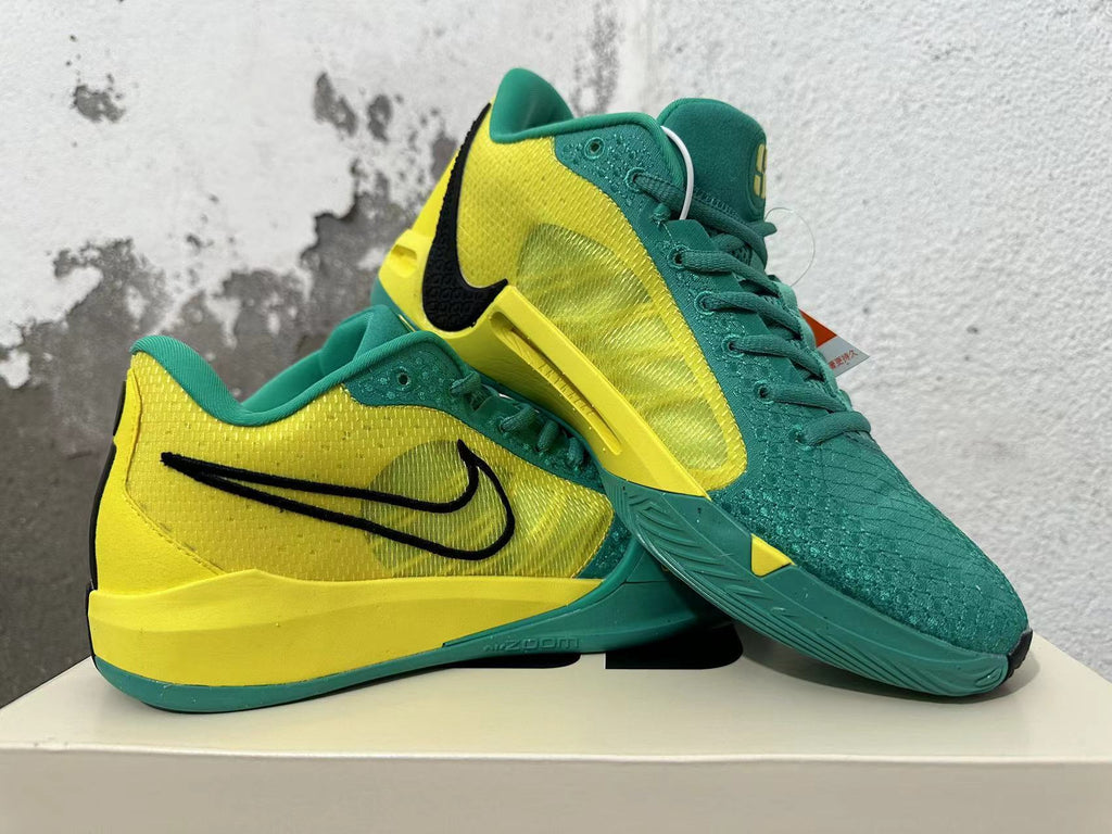 Pair of green and yellow Nike Kobe basketball shoes shown from the side and above.