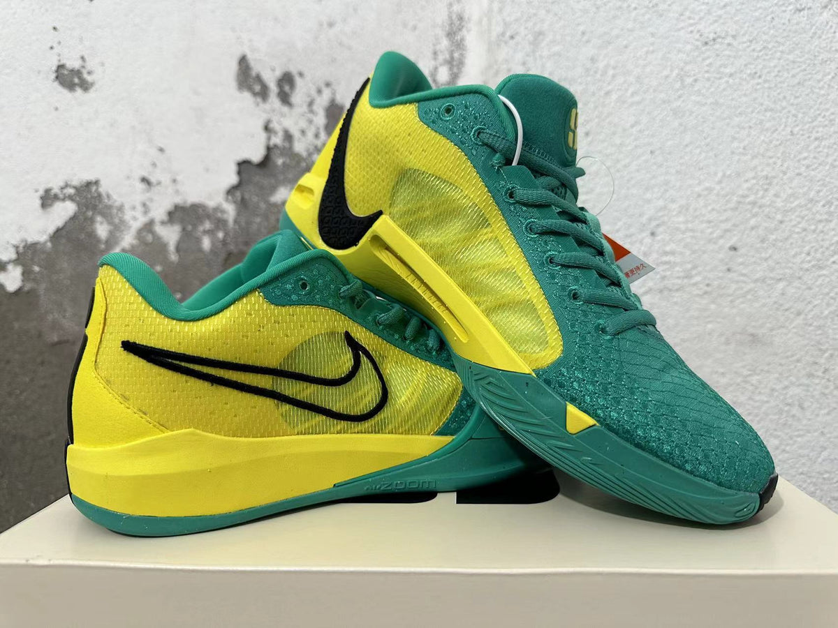 Pair of green and yellow Nike Kobe basketball shoes shown from the side and above.