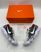 Pair of black-and-white graphic Nike shoes pictured with an orange Nike box and printed insert.