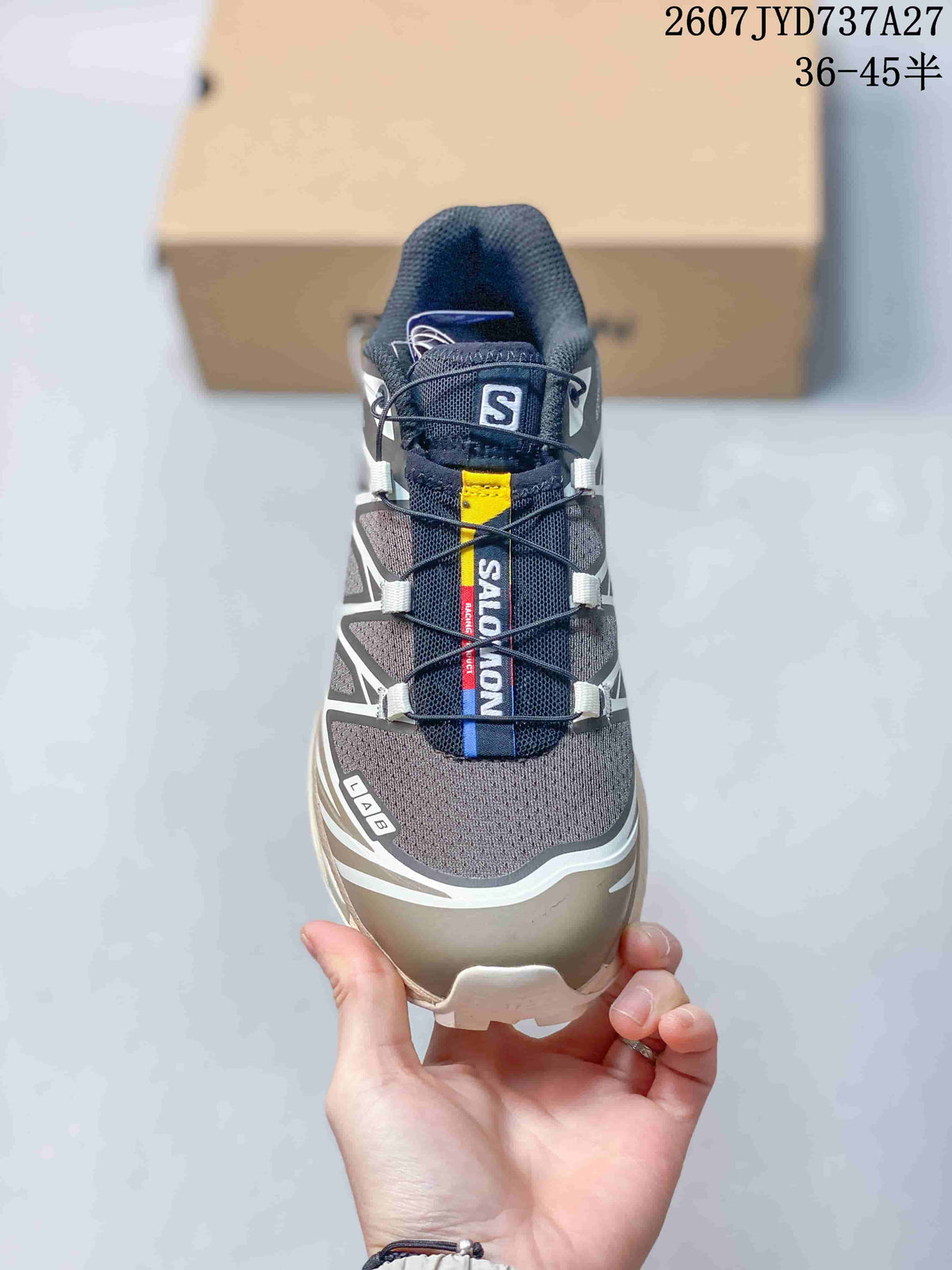 Front view showing the gray toe box, navy tongue, yellow accent, and branded lace area.