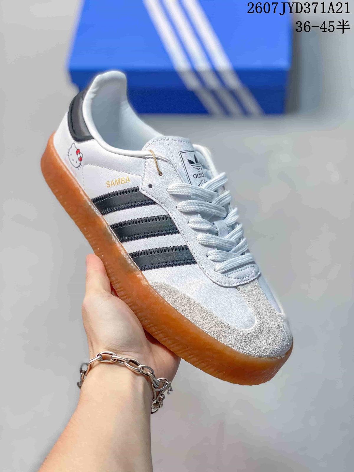Angled side view showing the Samba branding, black stripes, white upper, and gum sole.