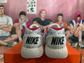 Rear view of Nike shoes showing the heel logos, mottled upper, red trim, and speckled sole.