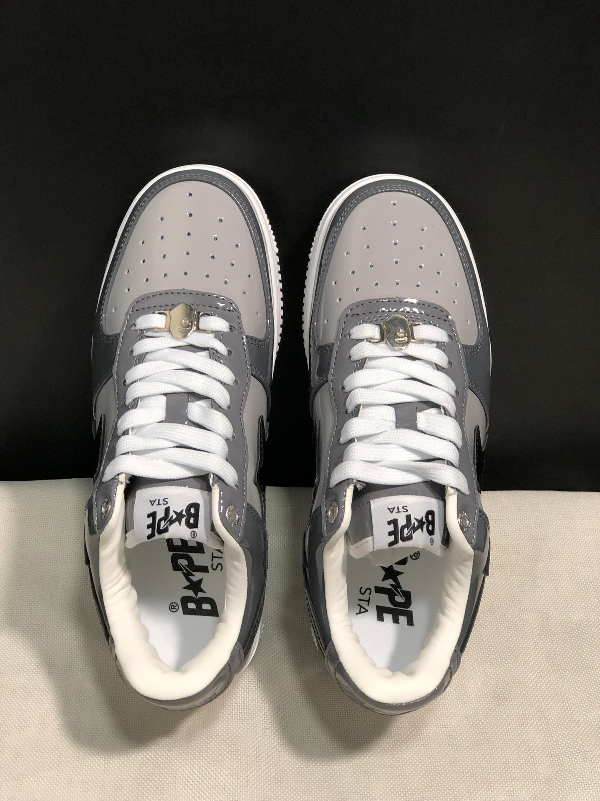 Top-down view showing perforated toe panels, white laces, and branded insoles.