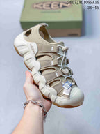 Angled side view of the beige Keen sandal showing the closed toe, adjustable straps, open heel, and gum-colored outsole.