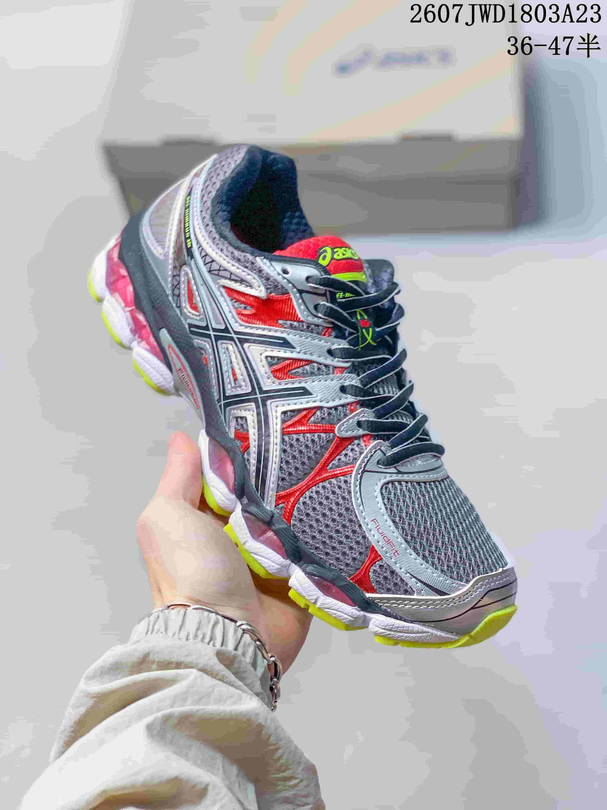 Gray, black and red ASICS Gel-Nimbus 16 sneaker with neon outsole accents.