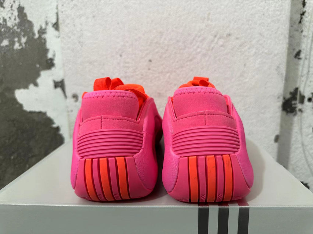 Rear view of pink Adidas basketball shoes with orange heel accents