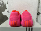 Rear view of pink Adidas basketball shoes with orange heel accents