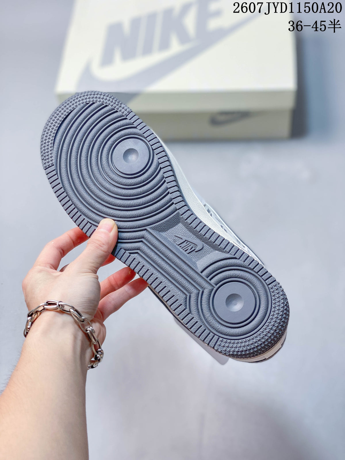 Close view of the gray rubber outsole with concentric circular traction patterns and textured edges.