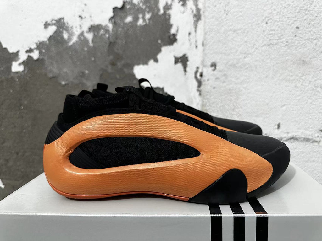 Side view highlighting the orange panels and black upper.