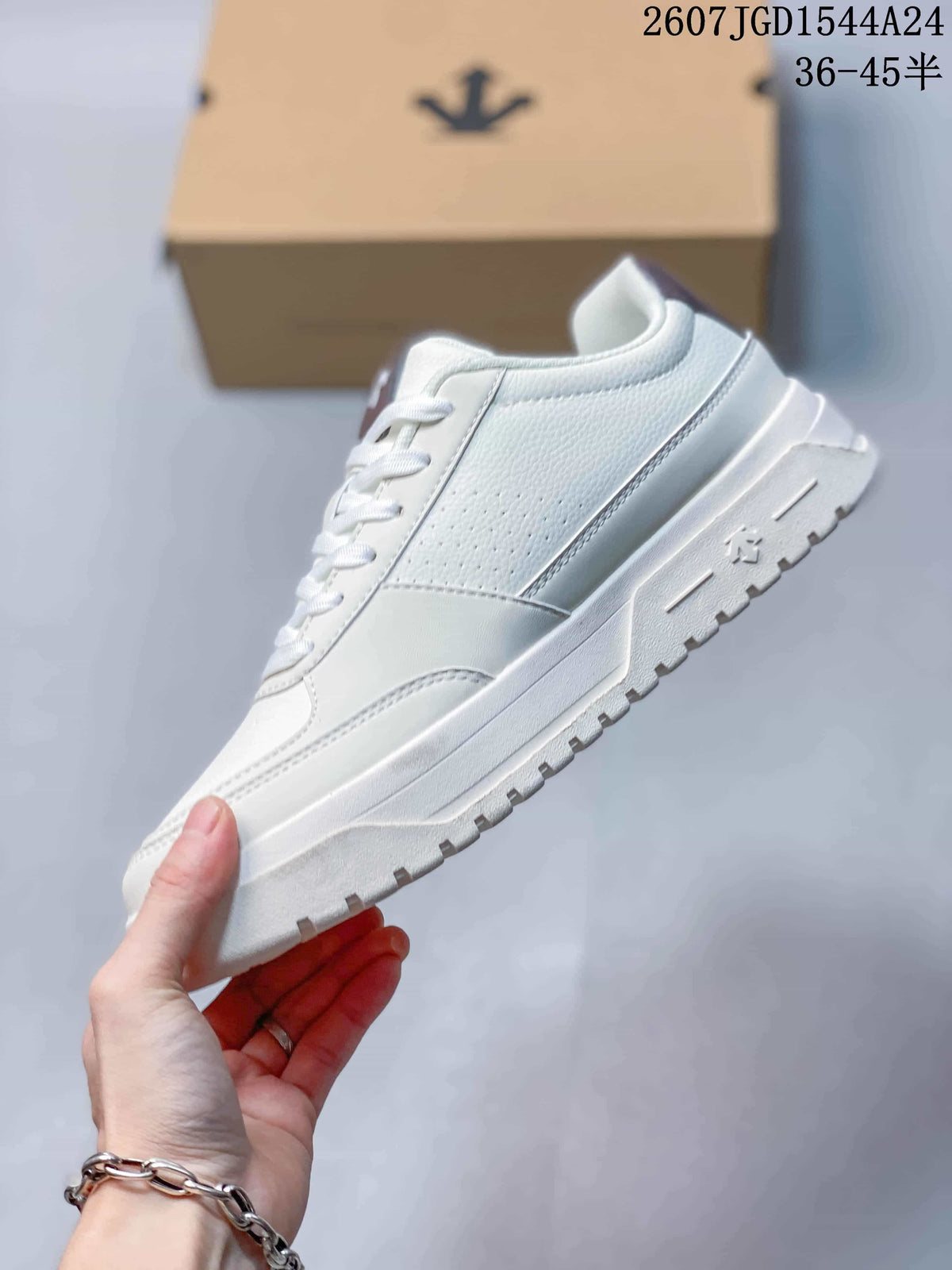 Side view of the white low-top sneaker showing perforated panel detailing, stitched overlays, and a raised white sole.