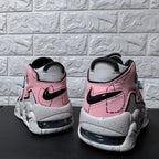 Rear view of pink and grey Nike sneakers with black Swoosh details and heel cushioning windows