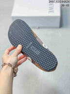 Underside view showing the dark rubber outsole with a wavy tread pattern and embossed branding.