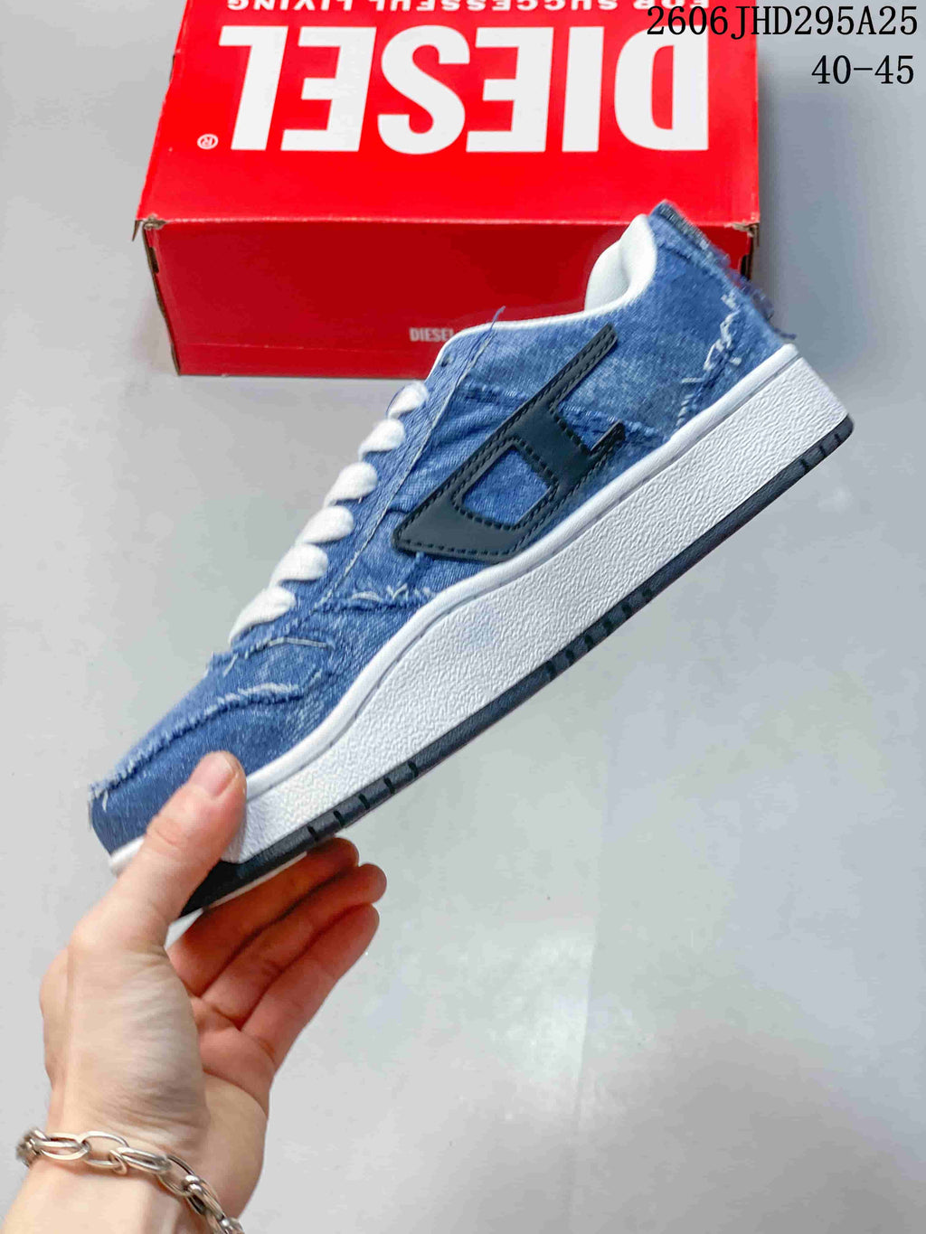 Side view of the low-top sneaker showing distressed blue denim-look panels, black side detail and white midsole.