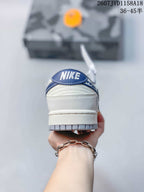 Rear view of the sneaker showing the blue heel tab and layered low-top construction.
