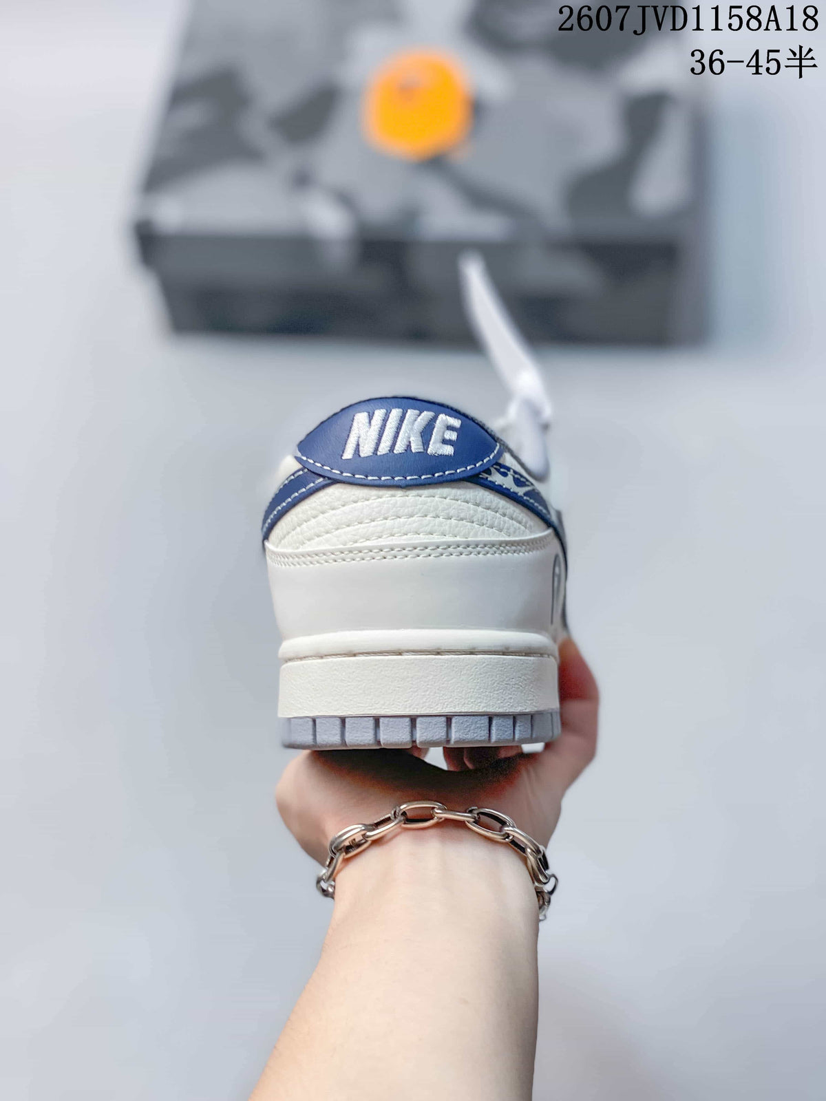 Rear view of the sneaker showing the blue heel tab and layered low-top construction.