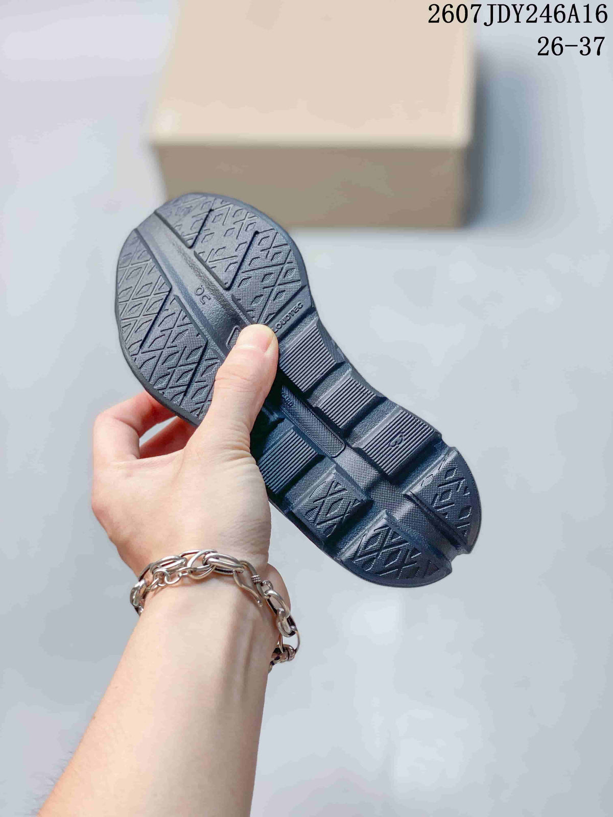 Underside of a dark gray sneaker showing the geometric outsole tread pattern.