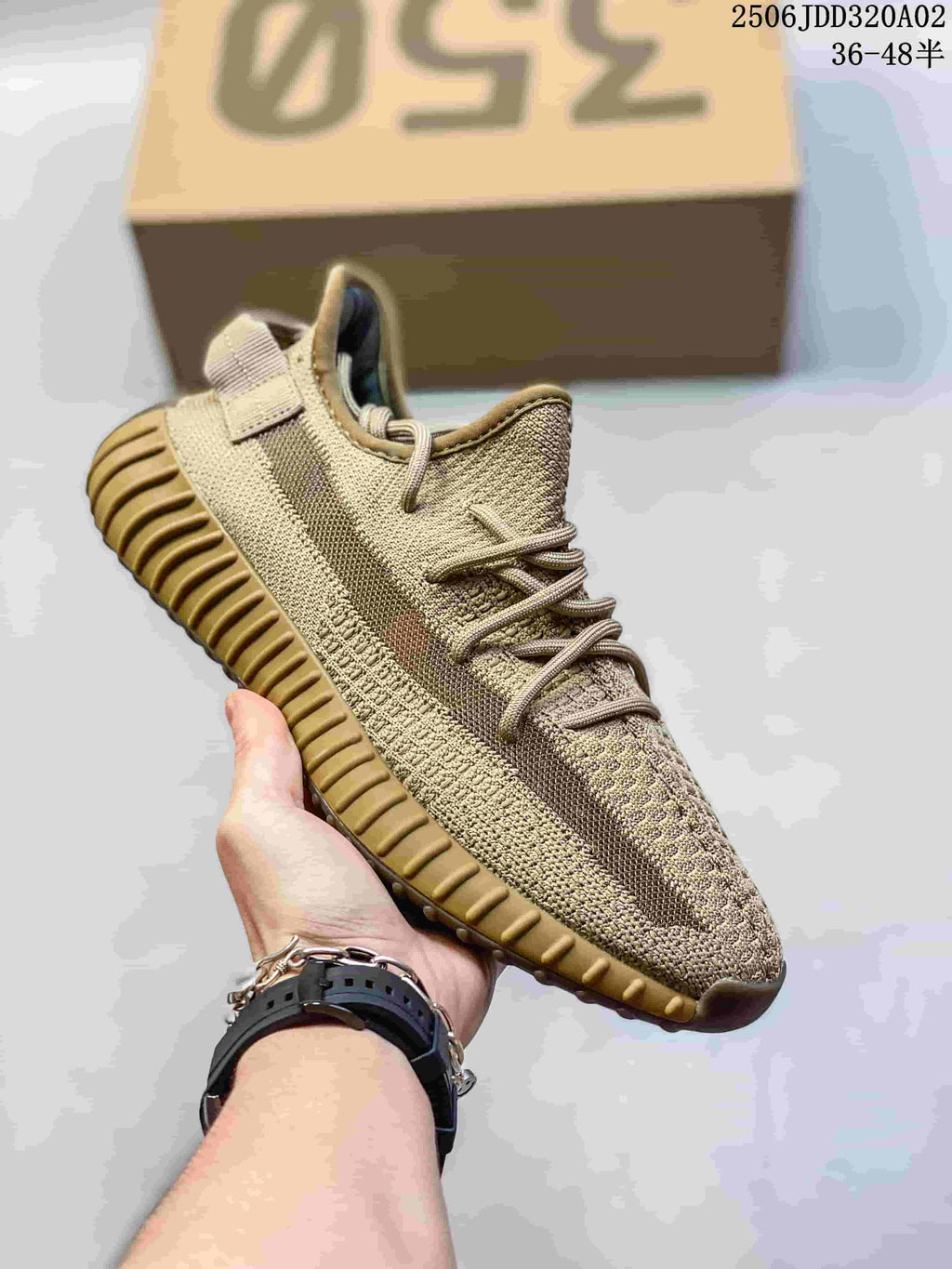 Angled side view of a beige Adidas Yeezy Boost 350 sneaker showing the side stripe, lace system, and tan ribbed outsole.