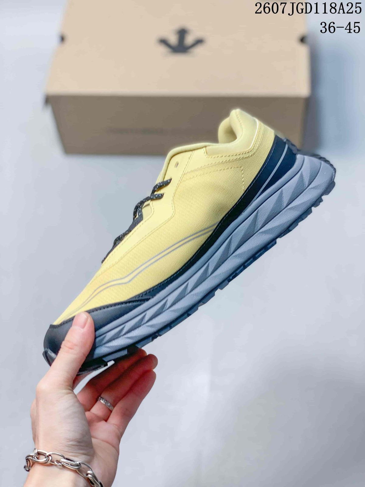 Side view of the yellow and black low-top sneaker with layered gray midsole detailing.