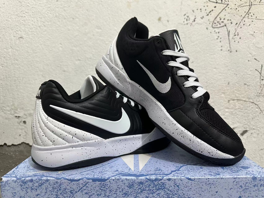 Pair of black and white basketball shoes shown from the side