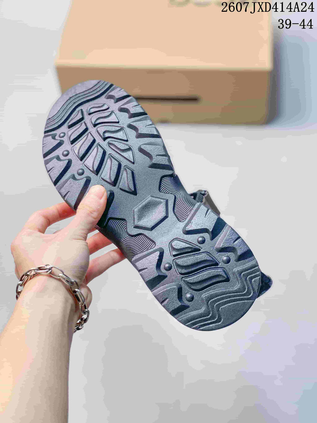 Close-up of the sandal outsole showing its dark, deeply textured tread pattern.