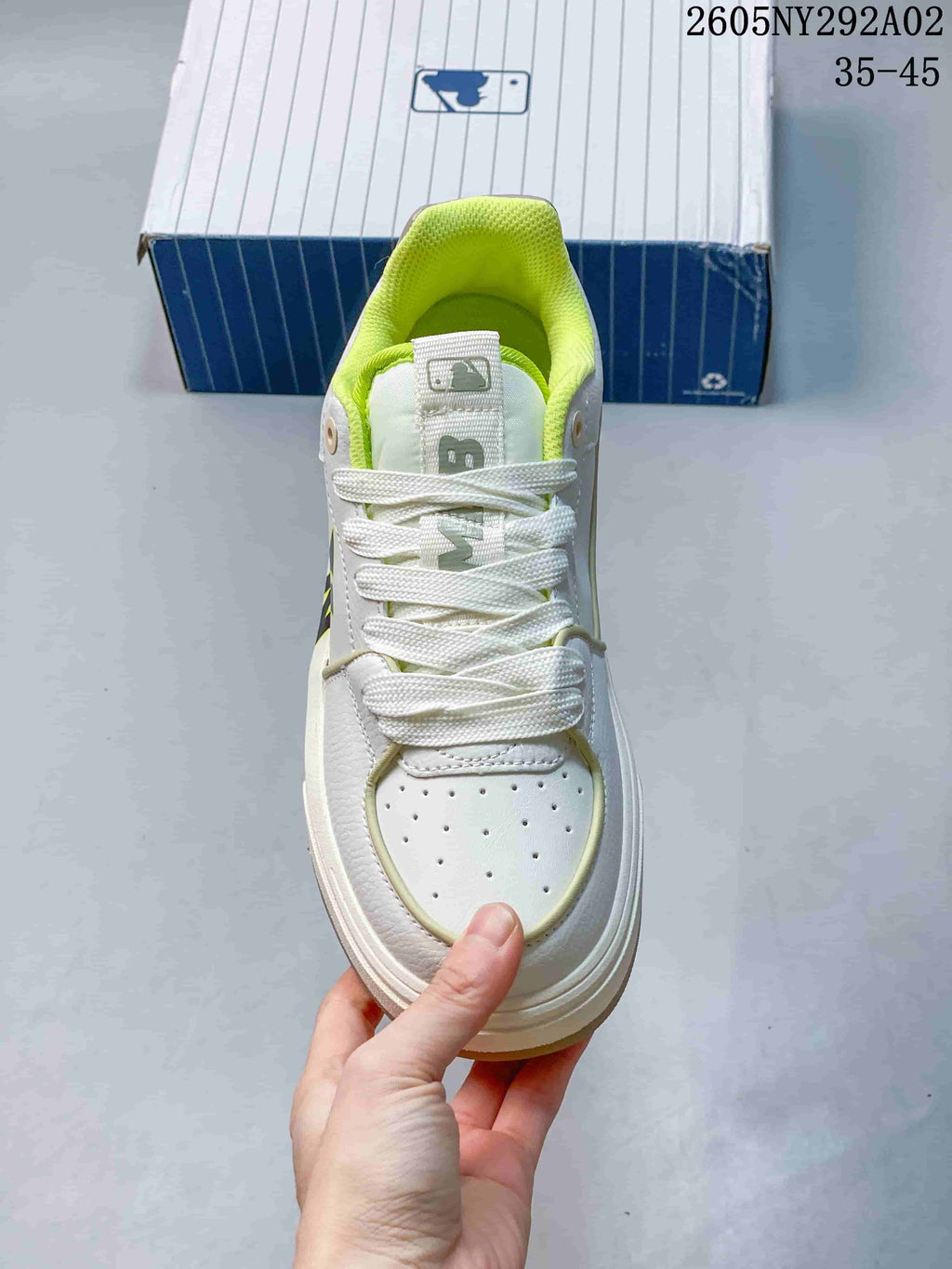 Top view of the white lace-up sneaker showing the perforated toe panel and neon-green collar.