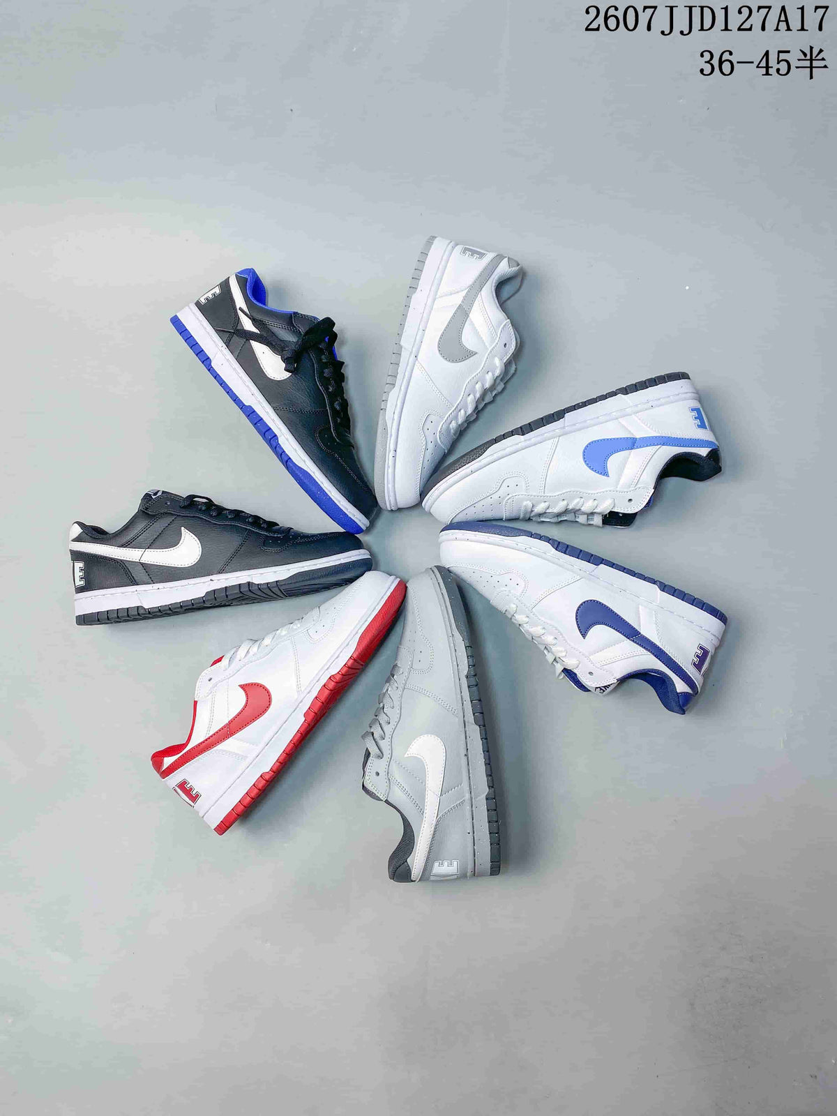 Group display of Nike SB Dunk Low Pro sneakers in black, white, gray, red, and blue color combinations.