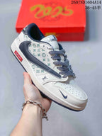 Angled side view showing the white and navy low-top sneaker, patterned side panels, layered Swoosh, and red side label.
