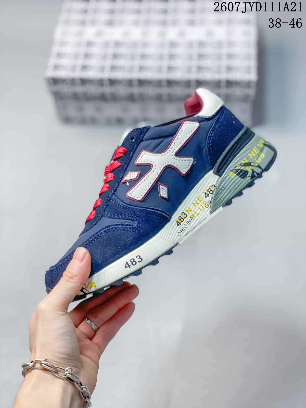 Side profile of the navy sneaker with white side detailing, red accents and a printed midsole.