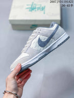 Side profile showing the blue-gray Swoosh, white upper, repeating script side-panel detail, white midsole and gray outsole.