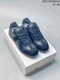 Pair of black Maison Margiela Replica Wedge low-top sneakers displayed on a shoe box, with the marking 2607JJD386A26 and size range 35–46 visible above.