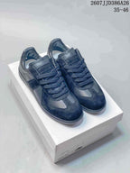 Pair of black Maison Margiela Replica Wedge low-top sneakers displayed on a shoe box, with the marking 2607JJD386A26 and size range 35–46 visible above.