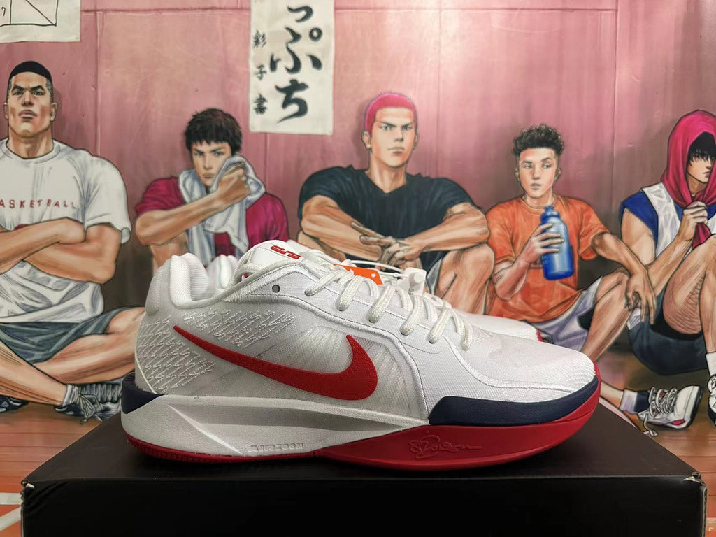 Side profile of a white Nike basketball shoe with red Swoosh and navy and red sole accents.