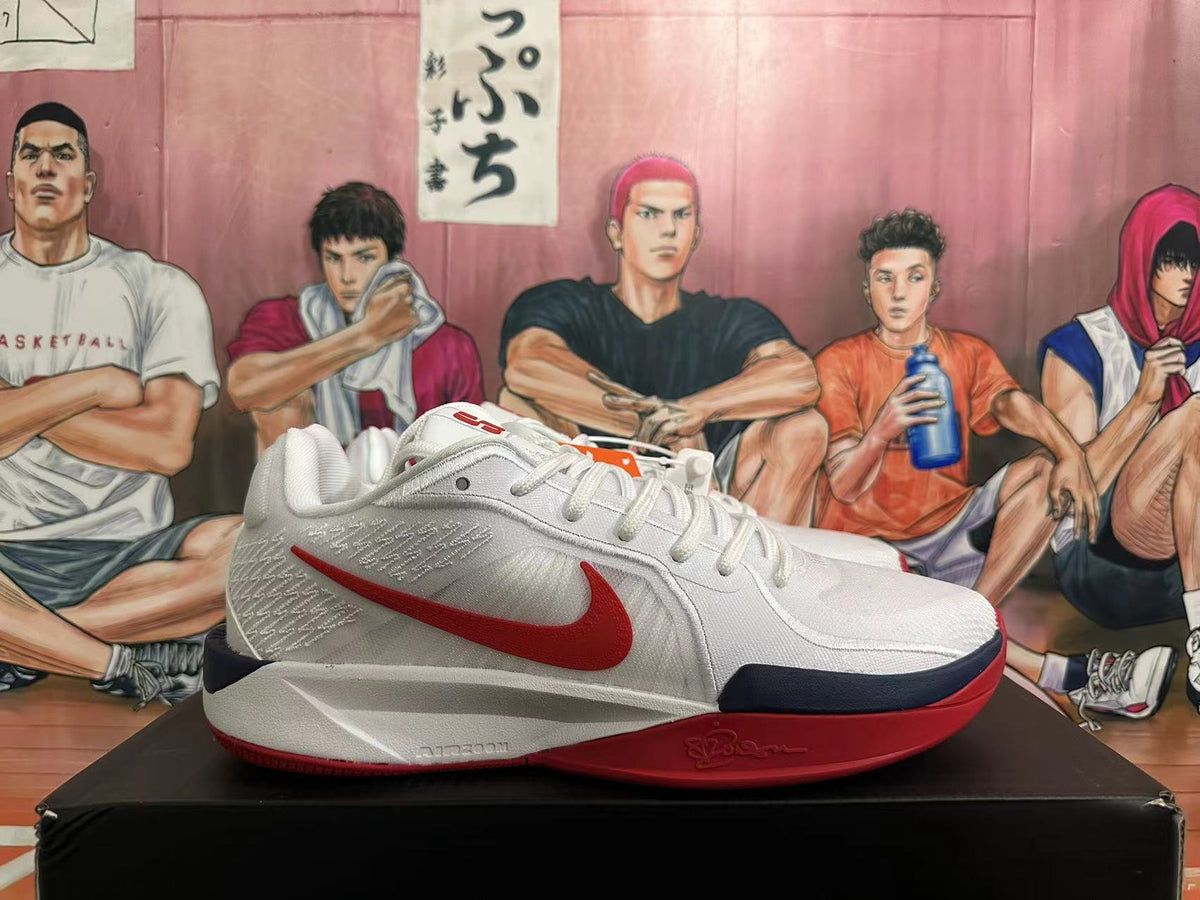 Side profile of a white Nike basketball shoe with red Swoosh and navy and red sole accents.