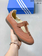 Close-up side view of the brown Samba Jane sneaker showing the T-strap closure, perforated detailing and textured outsole.