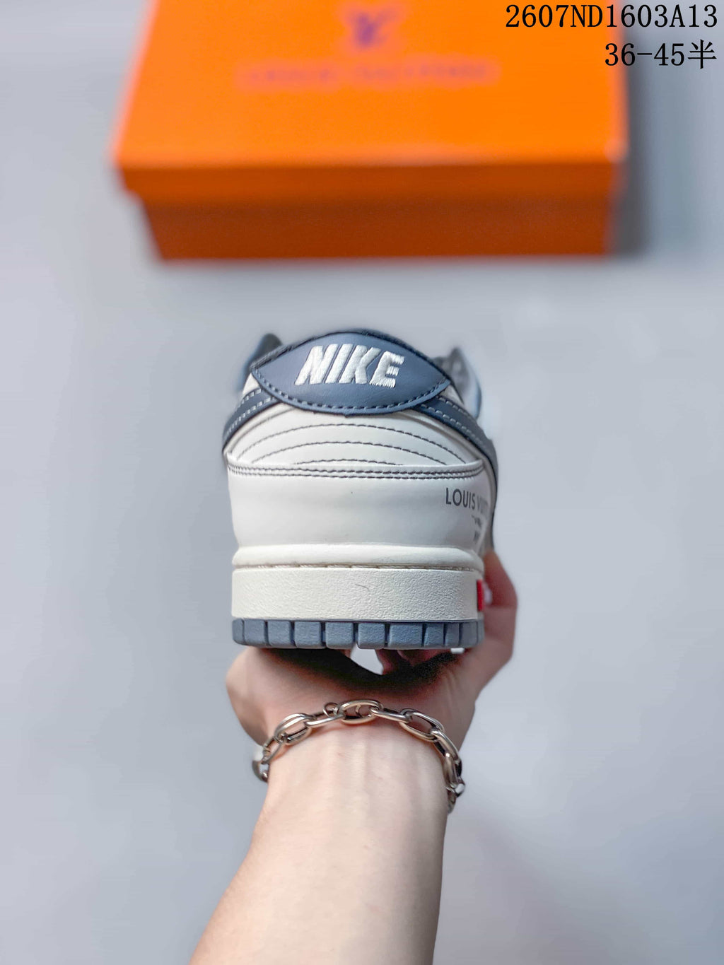Rear view of the sneaker showing the layered heel construction, grey outsole, and visible Louis Vuitton-style branding.