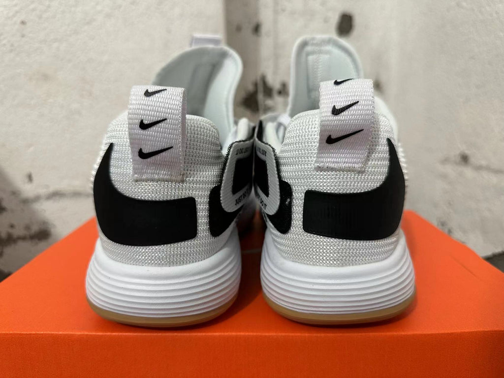 Rear view of white Nike basketball shoes with black heel details and gum-colored outsole edges.
