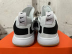 Rear view of white Nike basketball shoes with black heel details and gum-colored outsole edges.