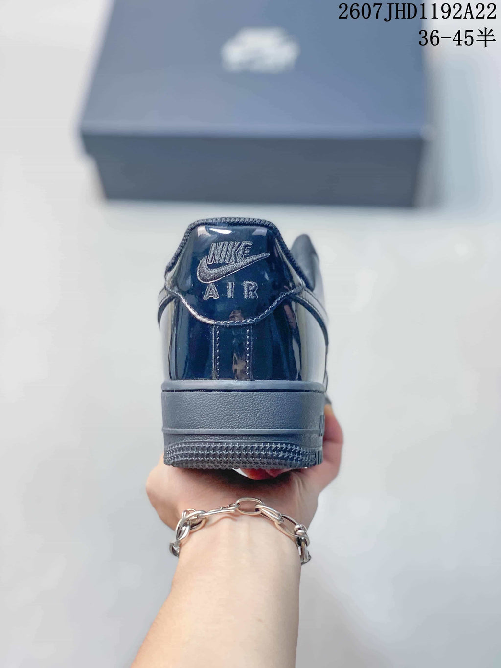 Rear view of a black Nike sneaker showing the padded heel, Air branding and textured outsole edge.