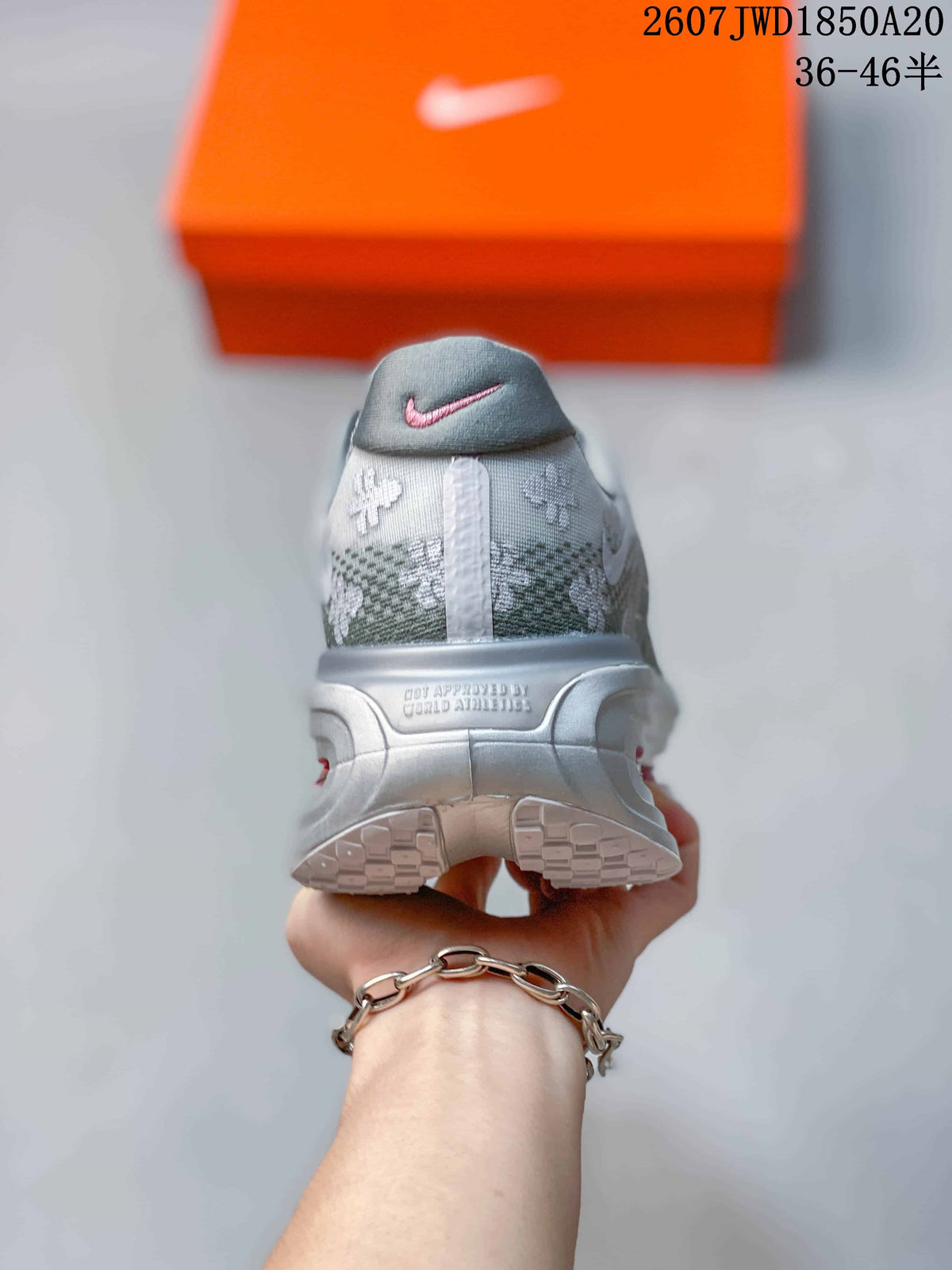 Rear view of the gray floral sneaker showing the heel branding, reflective-toned heel structure, and outsole tread.