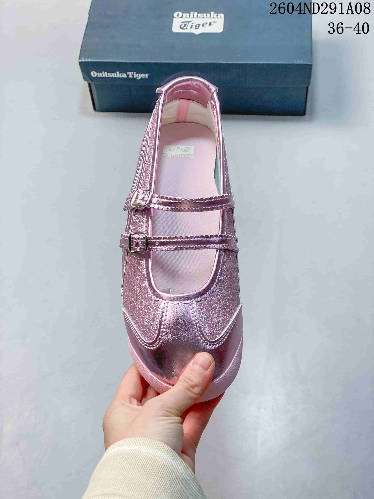 Top view of the pink sneaker showing its rounded toe, two buckle straps, and layered stitched panels.